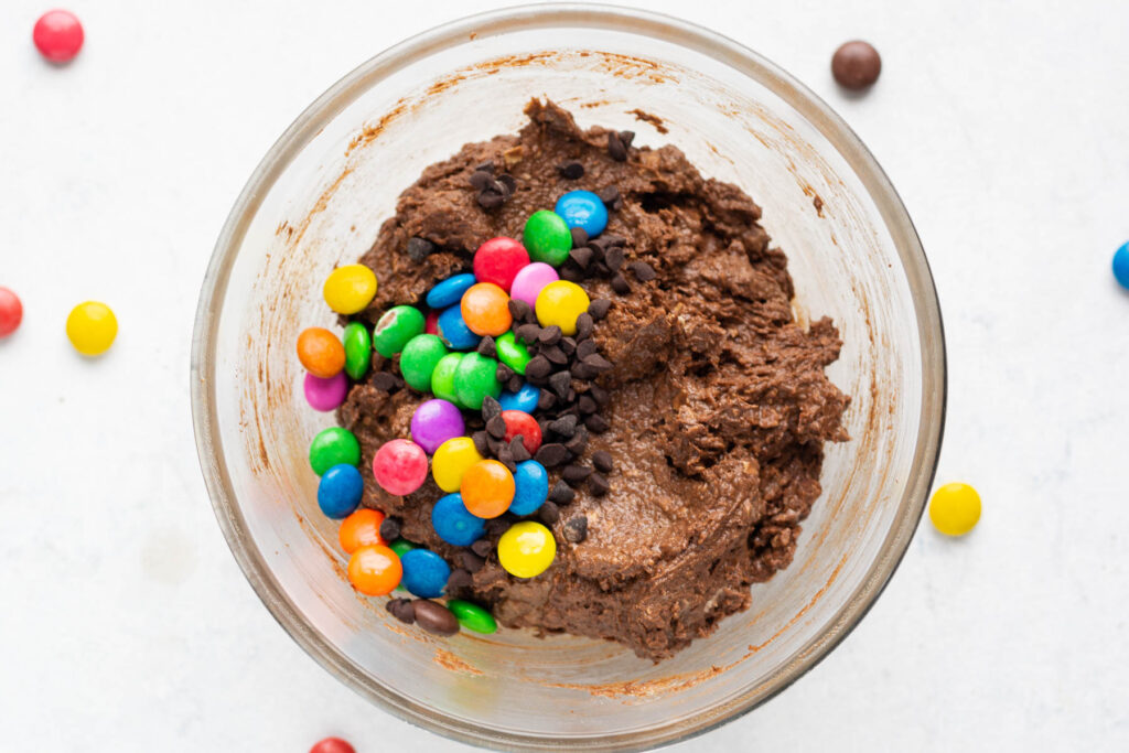 mixing in chocolate chips and M&M's in batter.