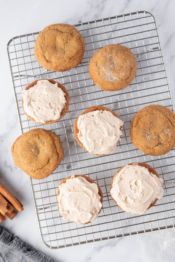 Soft and fluffy Ginger Molasses Cookie Sandwiches! Filled with a cinnamon buttercream frosting! Perfect for any cookie tray! Ginger Molasses Cookie Sandwiches on cooking rack.