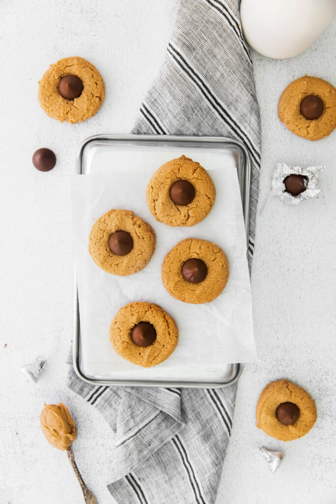 Soft and chewy Peanut Butter Blossom Cookies! A classic cookie filled with creamy peanut butter and chocolate kisses! overhead view of cookies.
