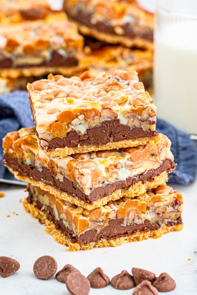 These Turtle Magic Bars are a fun twist on a classic recipe! With rich layers and great flavor these bars are the perfect treat! Turtle Magic Bars stacked with chocolate chips.