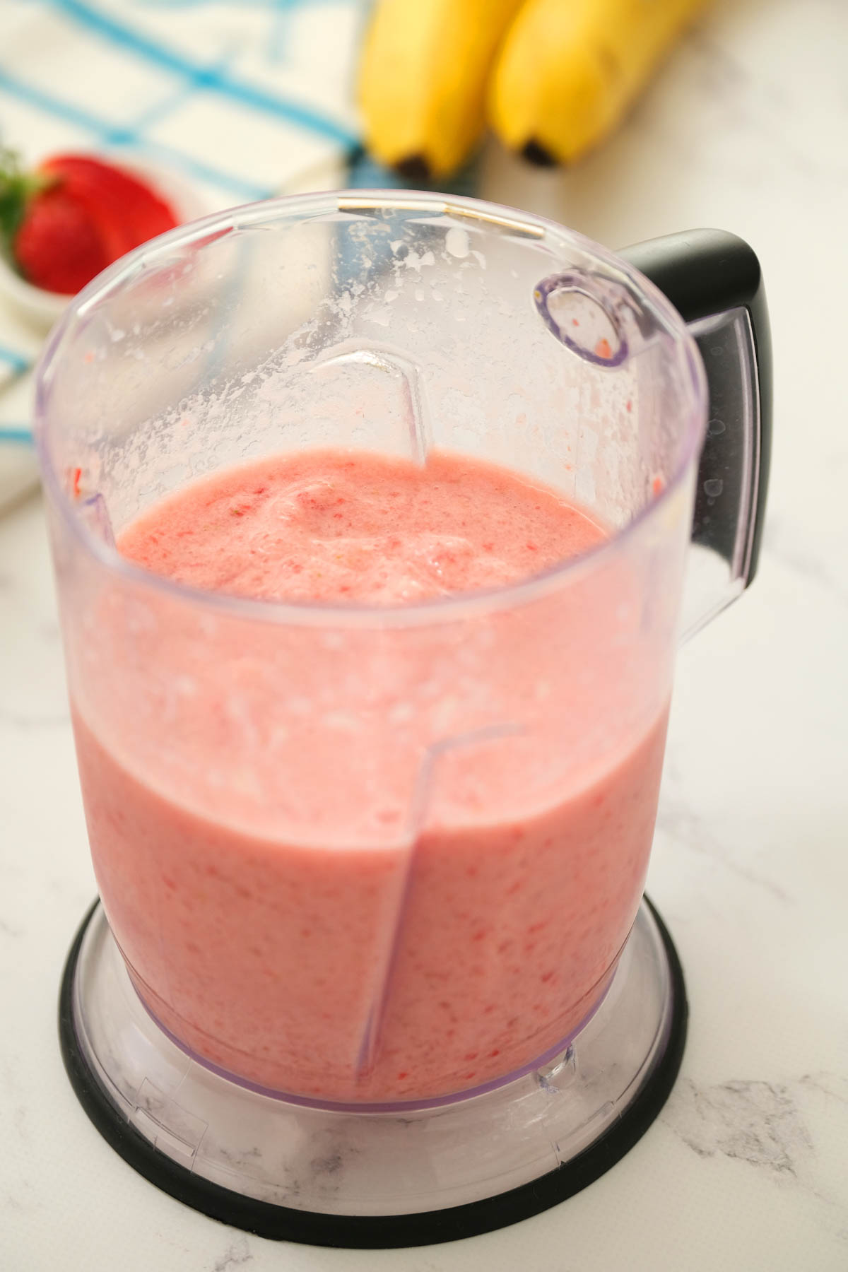Strawberry Banana Smoothie is so creamy and delicious! Full of strawberry flavor with a touch of banana! Makes for a perfect post workout treat! smoothie mixed in blender.