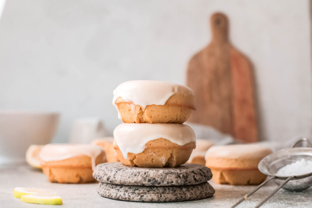 These Baked Lemon Donuts have a light and cake light texture that’s delicious and perfect to serve with a cup of coffee! Baked Lemon Donuts stacked on each other.