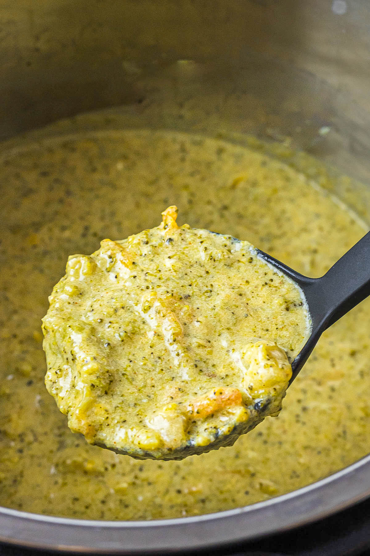 Instant Pot Broccoli Cheddar Soup in white bowl topped with cheese and crackers. Instant Pot Broccoli Cheddar Soup in ladle.