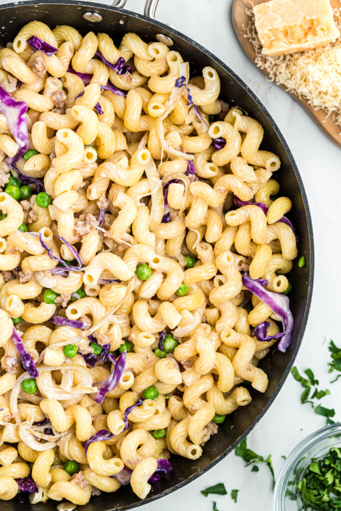 Easy Pasta with Sausage and Radicchio! Made with either penne or cavatappi, filled with vegetables and a cream sauce! pasta with sausage in skillet.