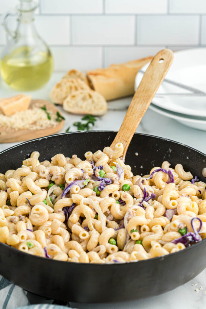 Easy Pasta with Sausage and Radicchio! Made with either penne or cavatappi, filled with vegetables and a cream sauce! Pasta with Sausage and Radicchio in skillet with spoon.