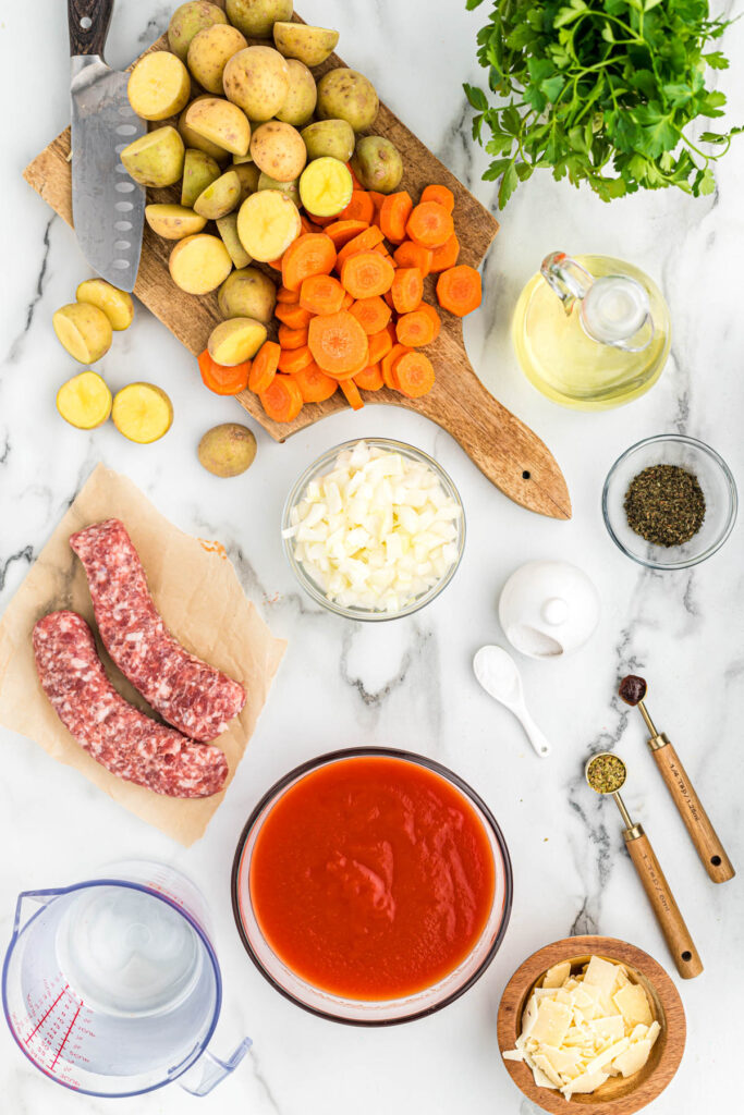 This Sausage Vegetable Soup is easy to put together and is the best comfort food. Loaded with vegetables and sausage! sausage vegetable soup ingredients laid out on white background.