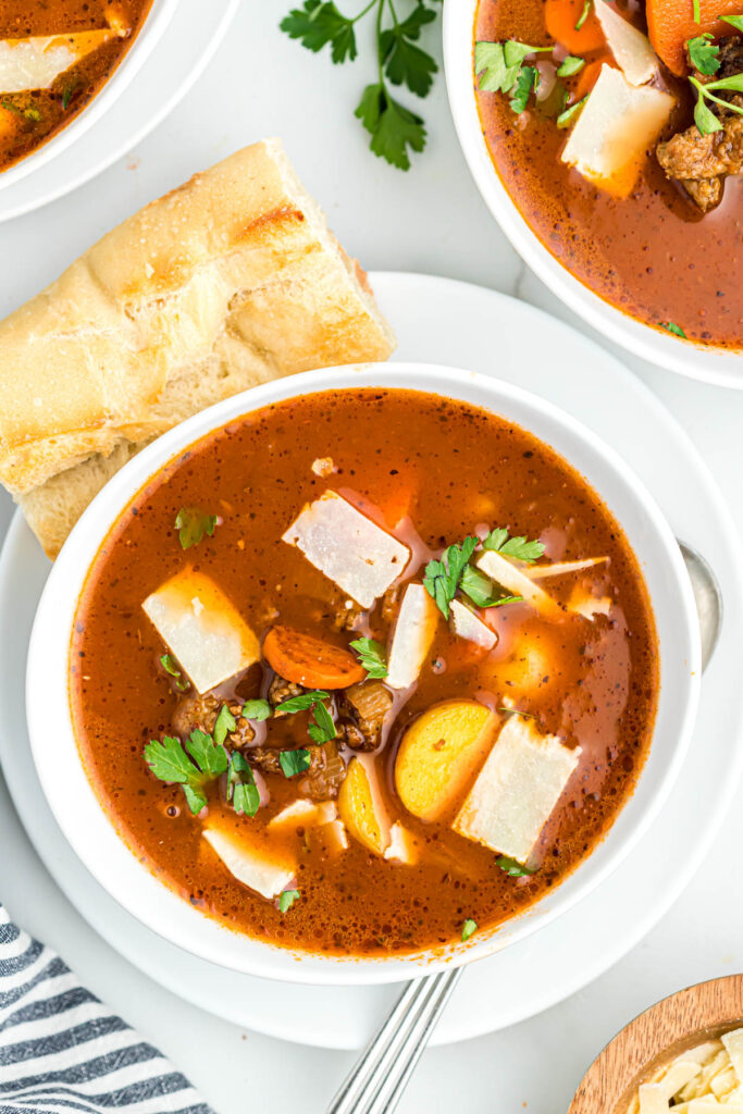 This Sausage Vegetable Soup is easy to put together and is the best comfort food. Loaded with vegetables and sausage! soup in white bowl on plate.
