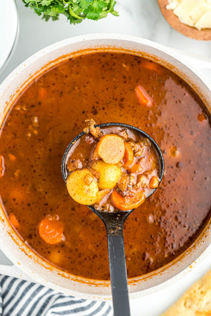 This Sausage Vegetable Soup is easy to put together and is the best comfort food. Loaded with vegetables and sausage! Sausage Vegetable Soup in ladle.