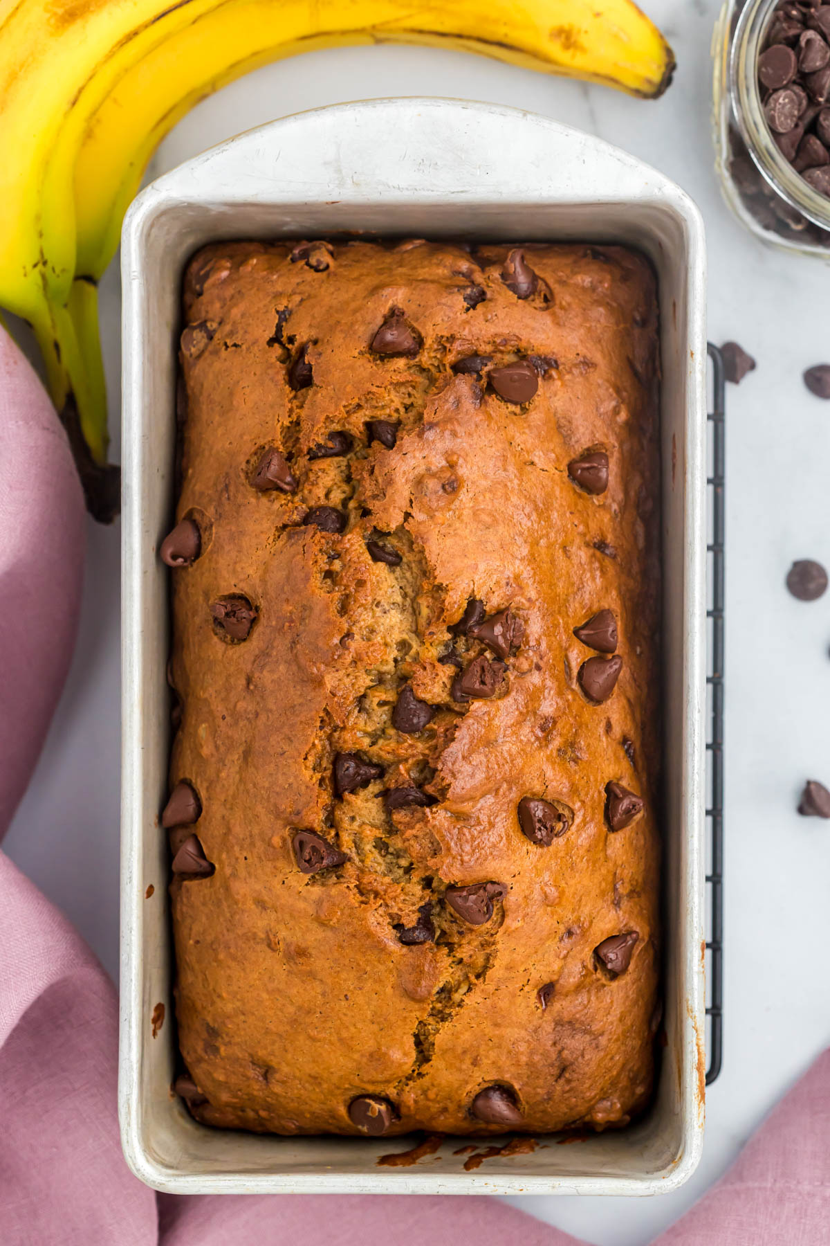 This Banana Chocolate Nut Bread is an easy and delicious quick bread! A one bowl recipe, loaded with nuts and chocolate chips! Banana Chocolate Nut Bread in loaf pan.