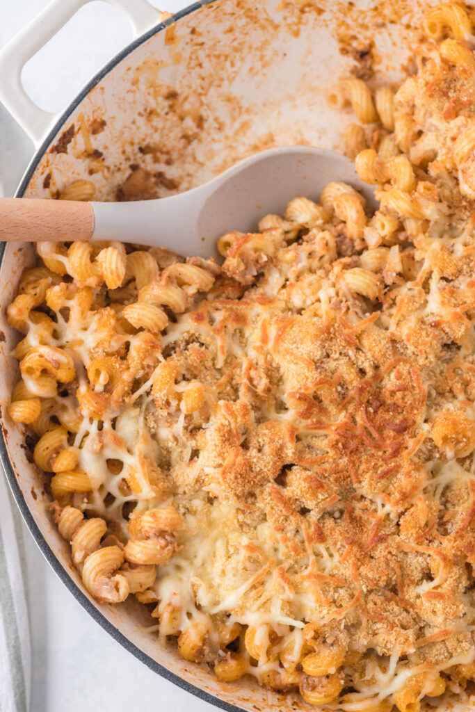 Sloppy Joe Pasta Casserole is perfect for busy weeknights when you want comfort food, minus the mess. Chock full of beef, noodles, and cheese! sloppy joe pasta casserole in pot with spoon.