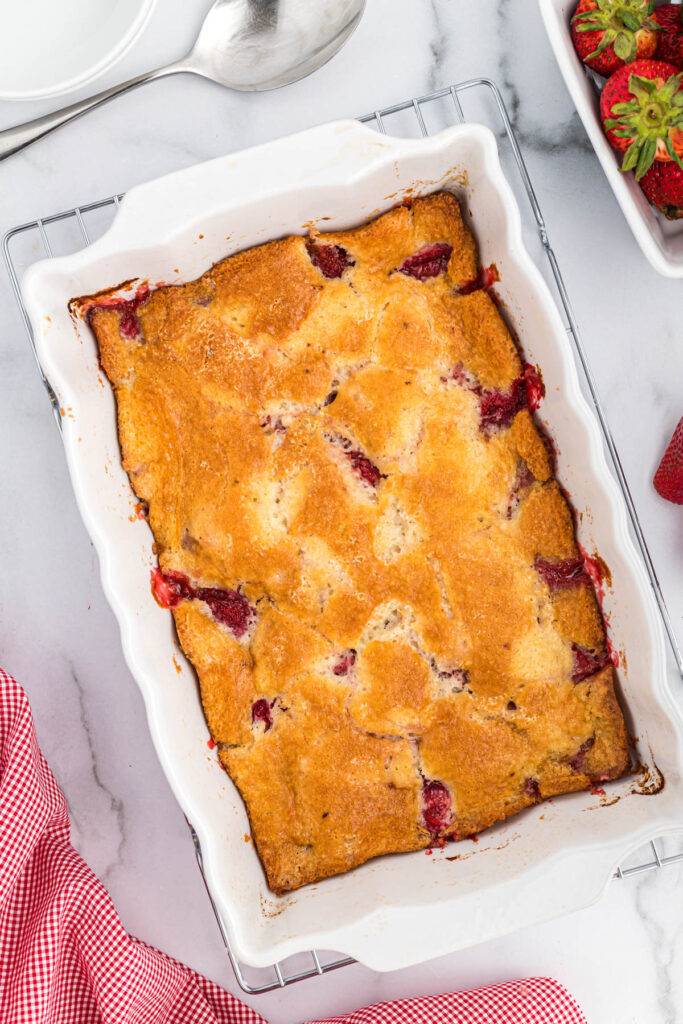 Easy Strawberry Cobbler! With an easy buttery crust mixed with fresh strawberries, this 6 ingredient dessert is perfect for summer! overhead view of cobbler in large dish.