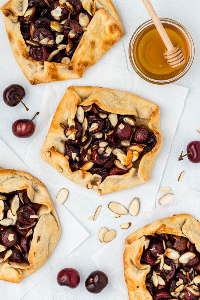 Mini Cherry Almond Galettes are the perfect individual desserts! Filled with fresh cherries, honey and almonds. Baked to perfection! overhead view of Mini Cherry Almond Galettes.