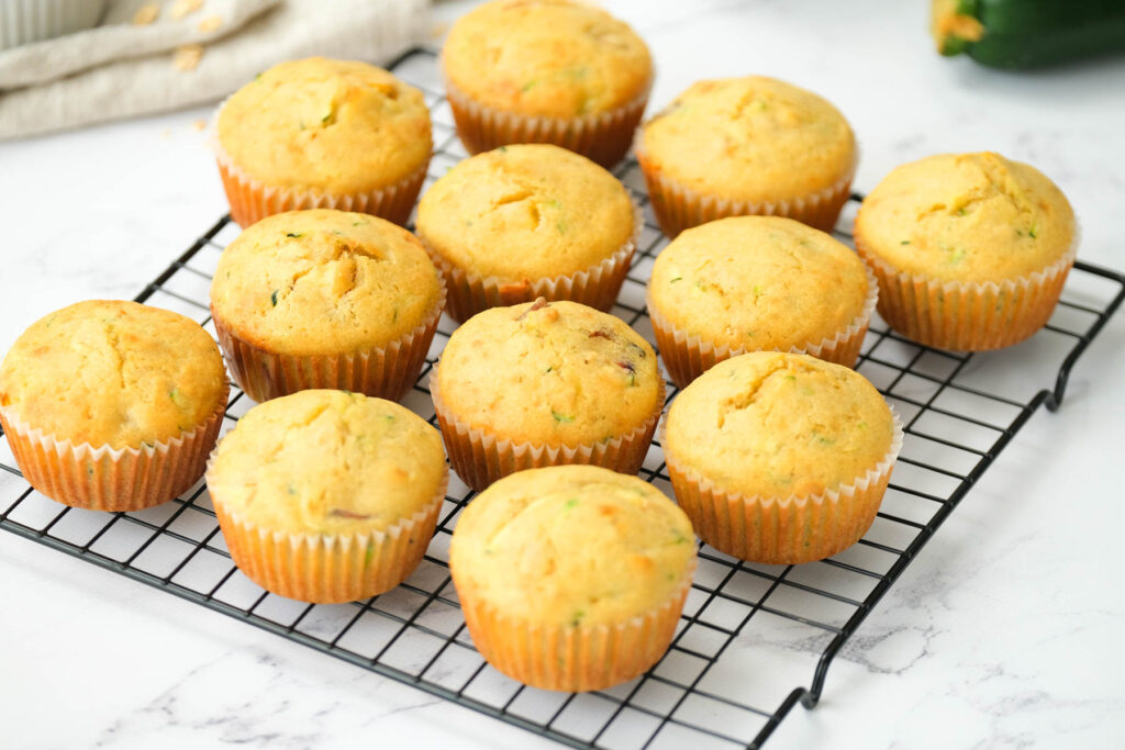 The BEST Peach Zucchini Oatmeal Muffins! Make these moist, flavorful muffins packed with peaches and a touch of zucchini! | The Bitter Side of Sweet muffins on wire rack.