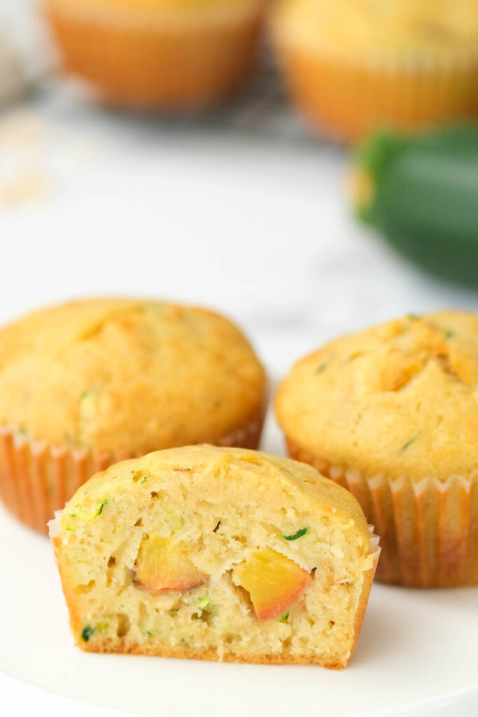 The BEST Peach Zucchini Oatmeal Muffins! Make these moist, flavorful muffins packed with peaches and a touch of zucchini! | The Bitter Side of Sweet Peach Zucchini Oatmeal Muffins cut open.