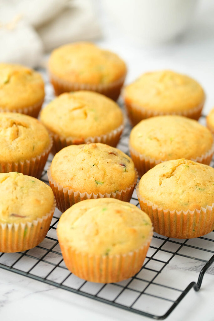 The BEST Peach Zucchini Oatmeal Muffins! Make these moist, flavorful muffins packed with peaches and a touch of zucchini! | The Bitter Side of Sweet muffins on black wire rack.