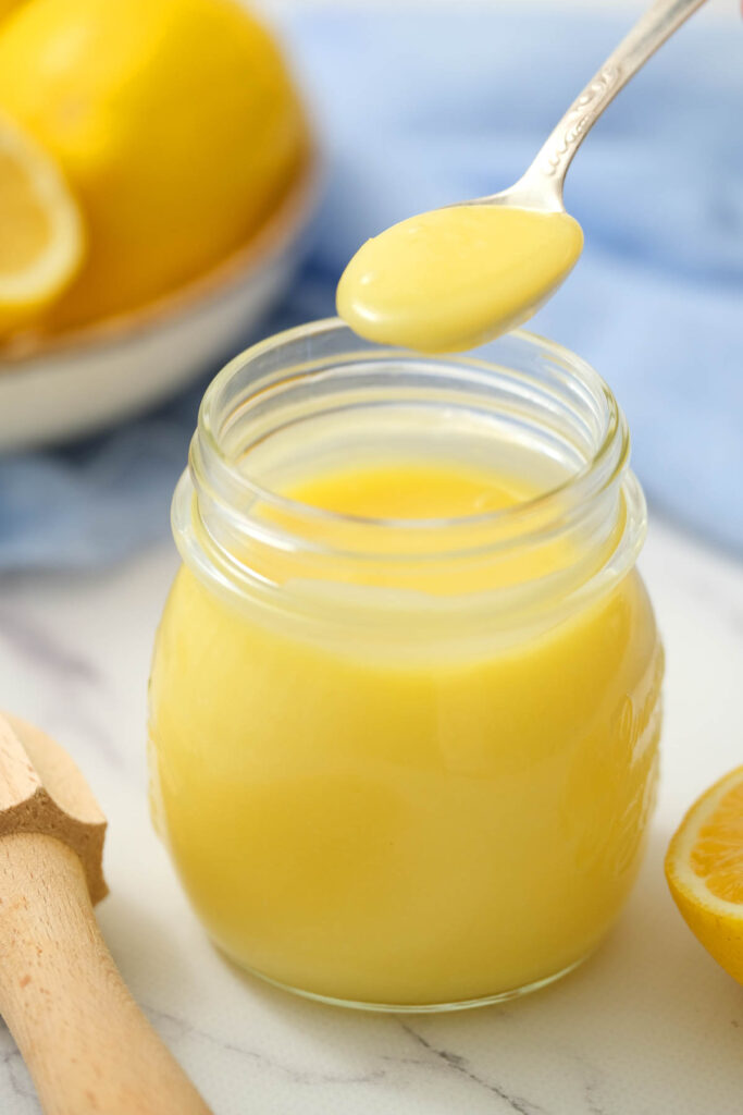 Easy Homemade Lemon Curd! Made with 5 simple ingredients, for a slightly sweet and tart dessert topping or spread! Homemade Lemon Curd on spoon.