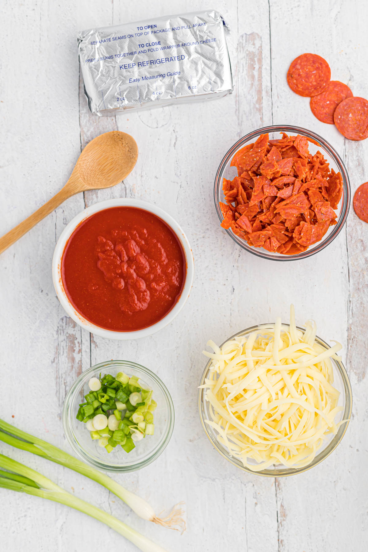 This ooey, gooey Easy Pepperoni Pizza Dip will satisfy any afternoon craving! Once you try this it will be a family favorite! ingredient for Pepperoni Pizza Dip on white background.