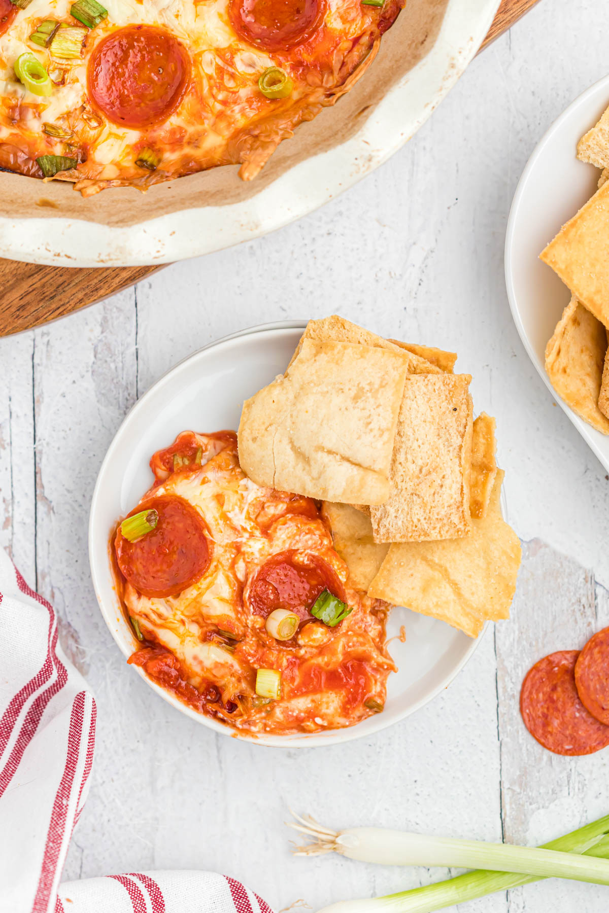 This ooey, gooey Easy Pepperoni Pizza Dip will satisfy any afternoon craving! Once you try this it will be a family favorite! Pepperoni Pizza Dip on plate with chips.