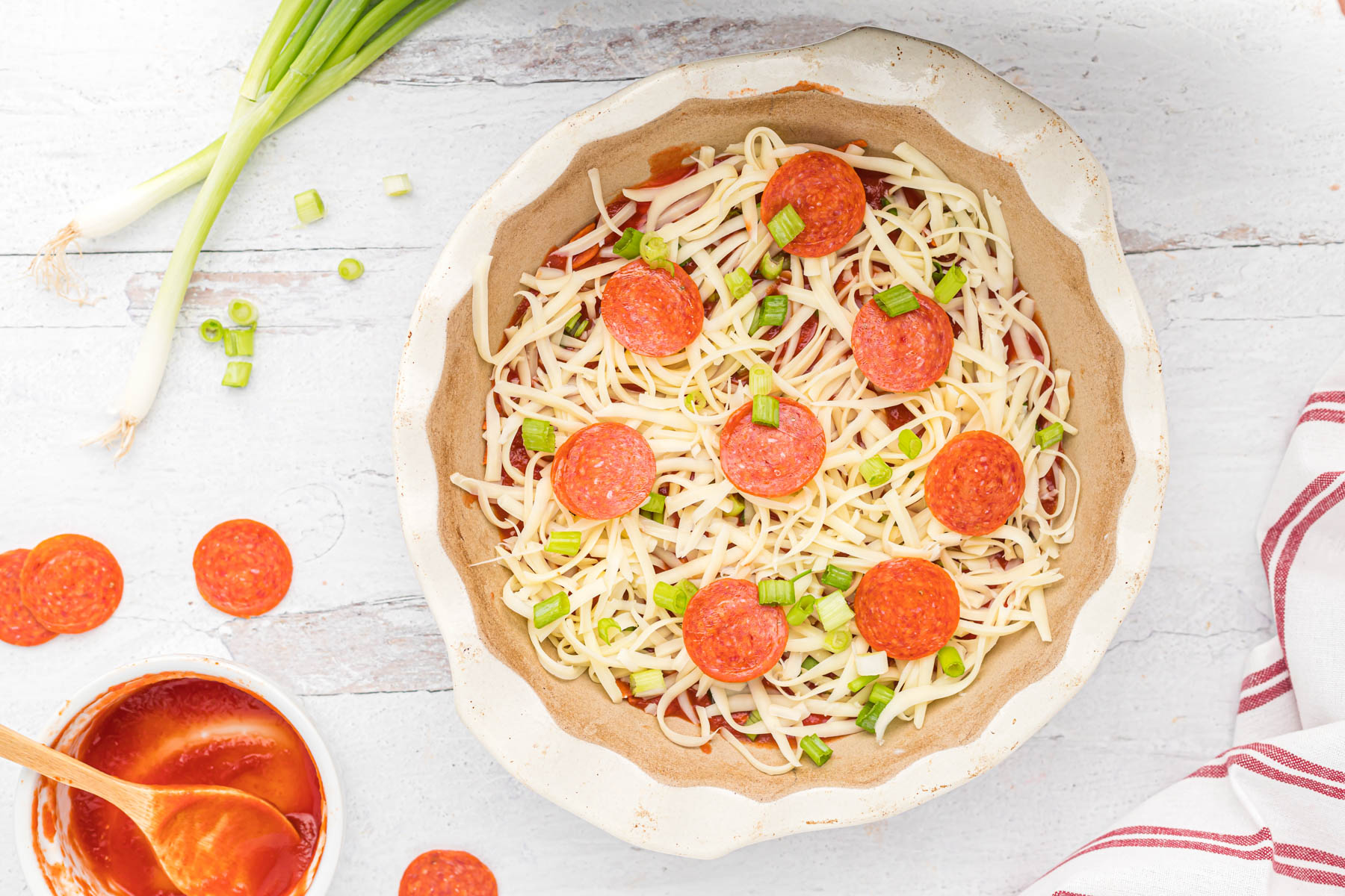 all ingredients for pepperoni pizza dip in baking dish.