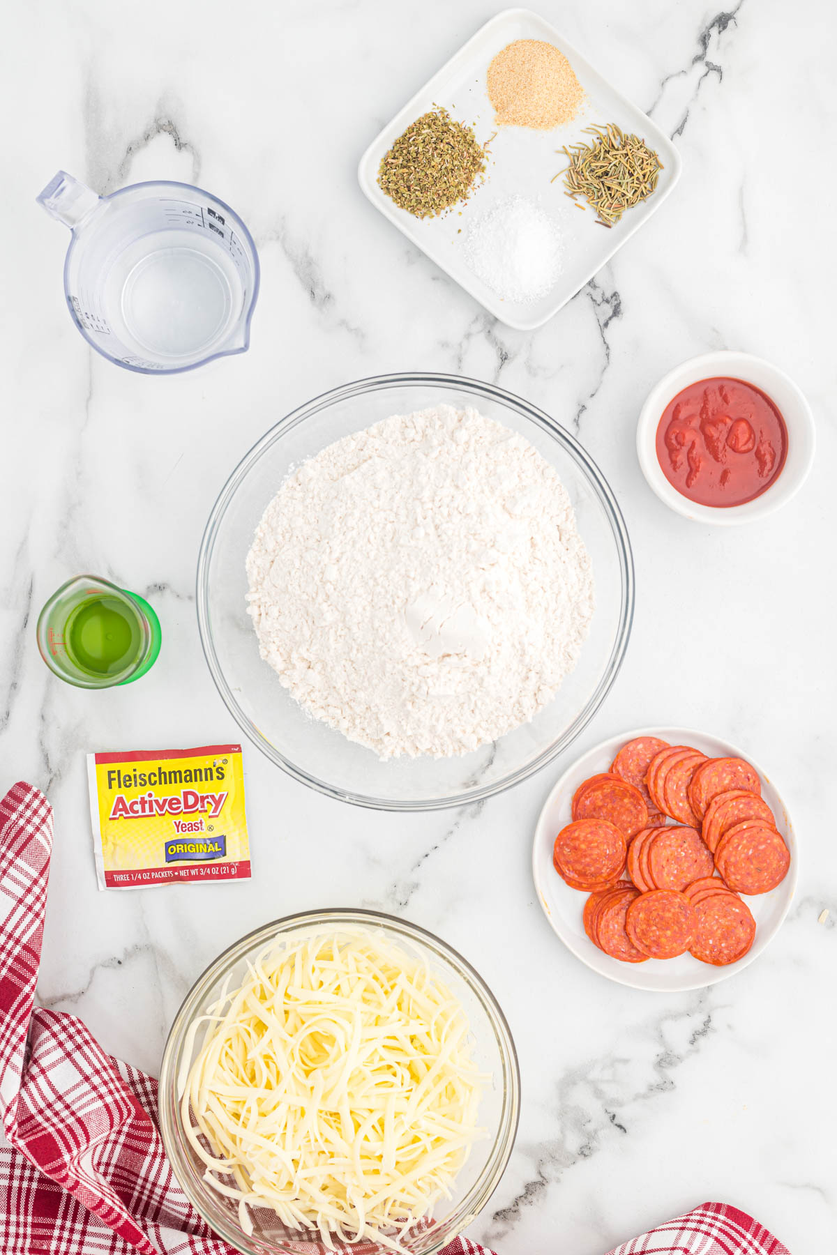 This homemade Pizza Dough recipe is perfect for any pizza night! Comes together in just a few minutes with just a few ingredients! ingredients for pizza dough on white background.