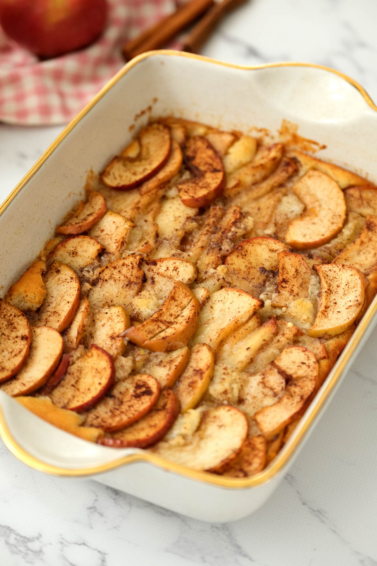 Easy Apple Cobbler that is so simple to make! Filled with the warm spice of cinnamon, embedded in a cake-like buttery topping! Baked easy apple cobbler in dish.