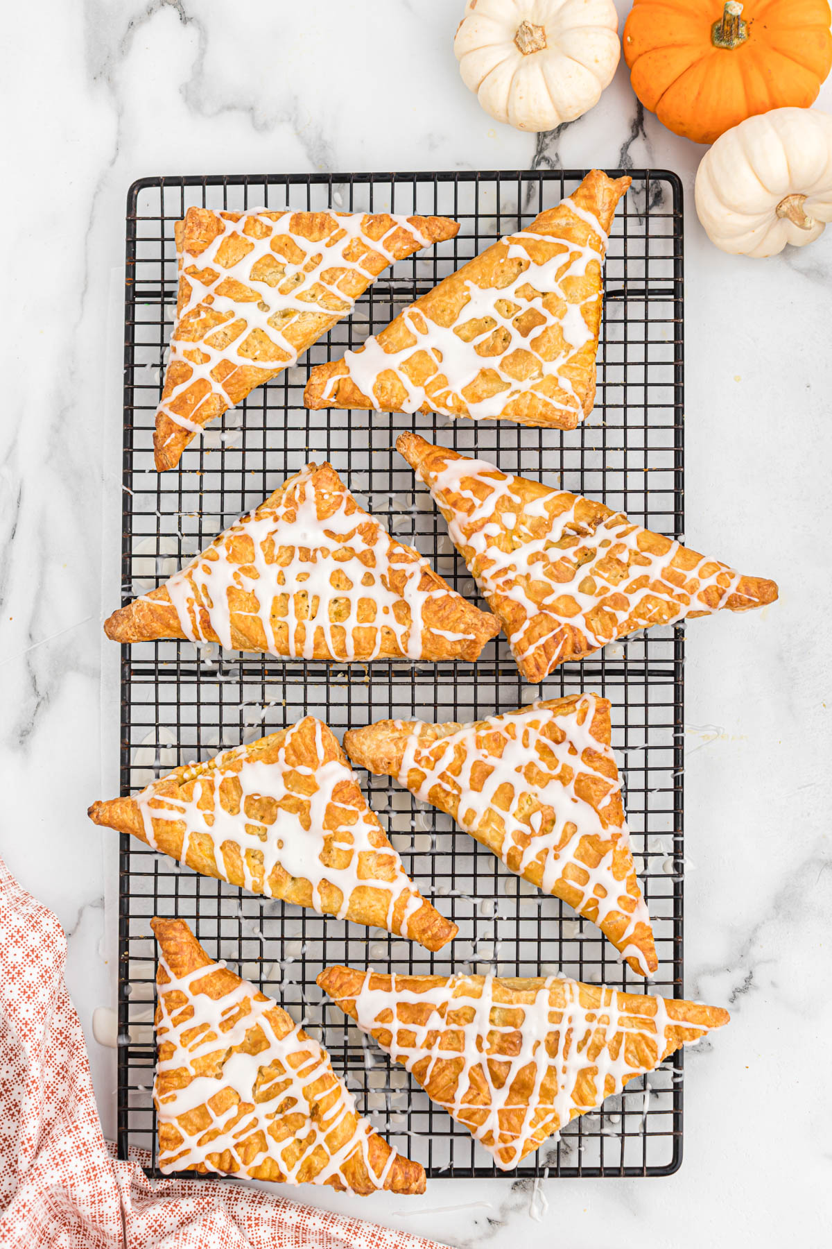 Air fryer pumpkin turnovers are the best fall dessert! Just a few minutes prep, these turnovers are flavored like pumpkin pie! Cooks quickly! easy air fryer pumpkin turnovers on cooling rack.