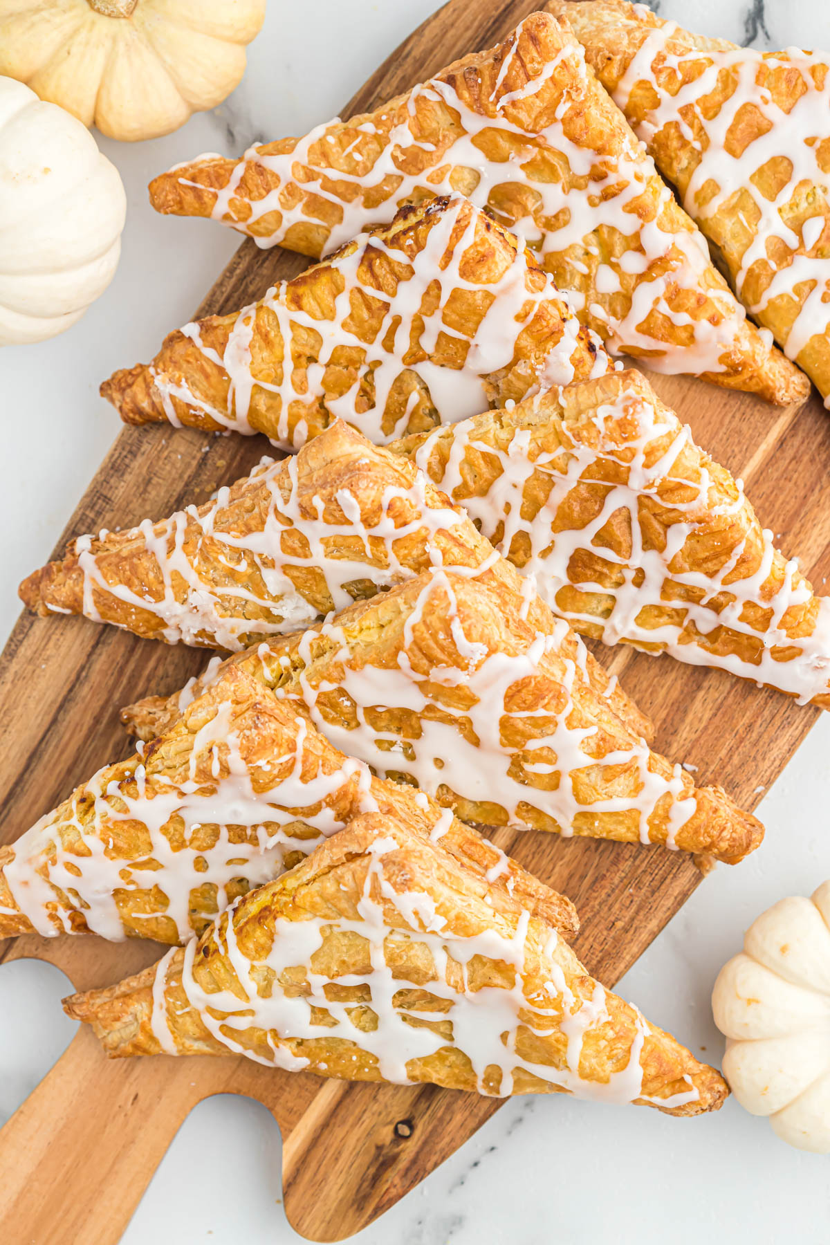 Air fryer pumpkin turnovers are the best fall dessert! Just a few minutes prep, these turnovers are flavored like pumpkin pie! Cooks quickly! pumpkin turnovers drizzled with glaze.