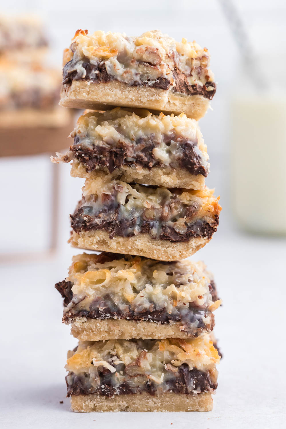 These seven layer magic bars are a classic dessert cookie bars. Made with just a few ingredients and baked to perfection! With a twist! classic seven layer magic bars stacked on top of each other.