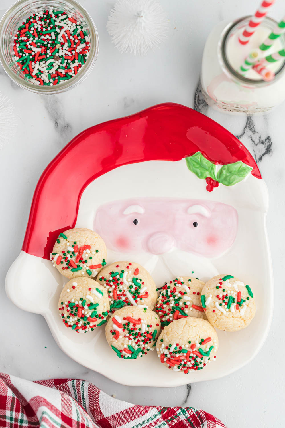 These easy Vanilla Christmas Cookies will be a favorite during the holiday season! With simple ingredients, even the kids can make them! Vanilla Christmas Cookies on Santa plate with glass of milk.