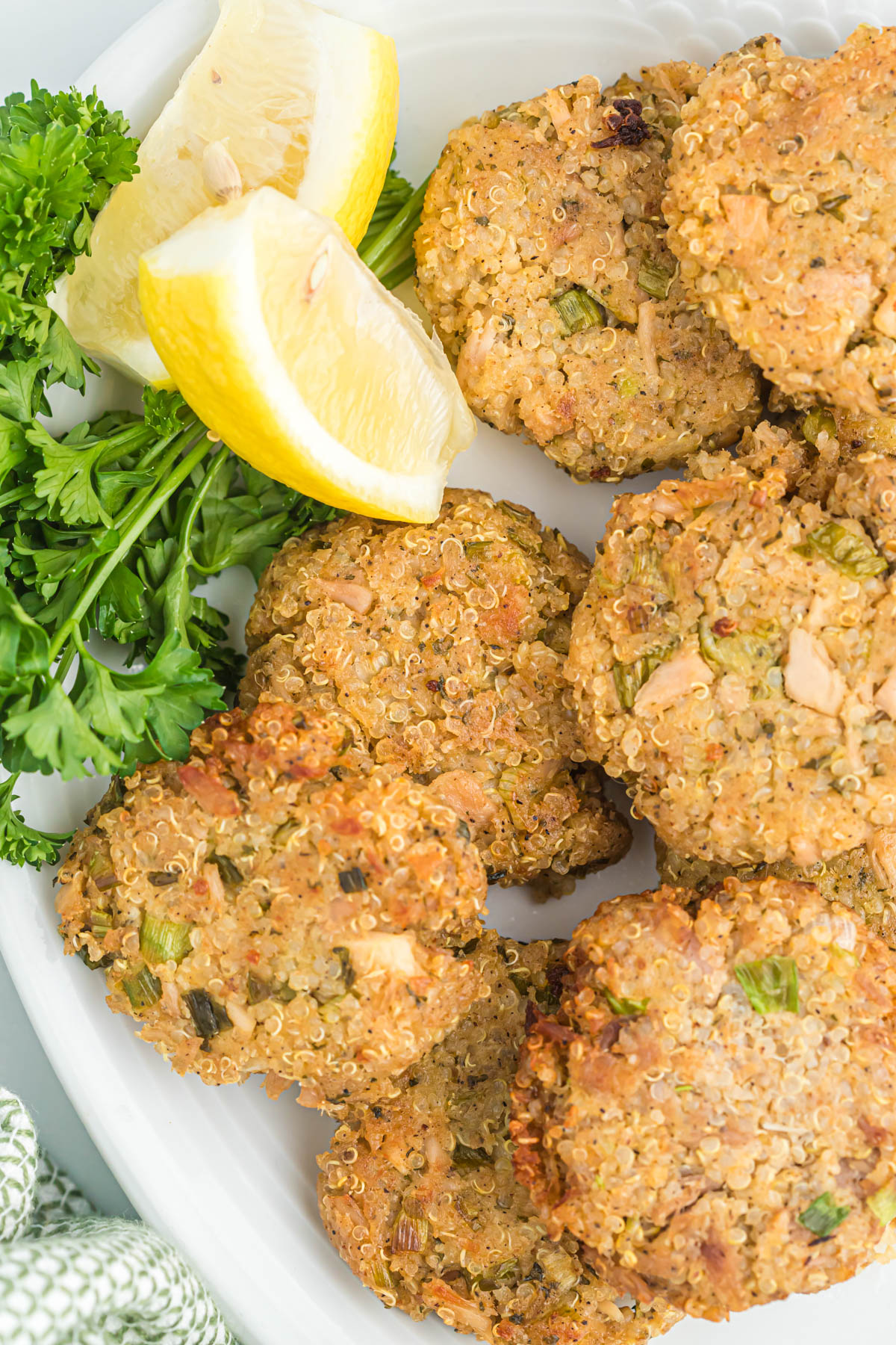 Tuna quinoa patties are a healthy and satisfying meal, packed with protein & fiber. Fried to golden perfection easy for a weeknight meal! Tuna Quinoa Patties on white plate with lemon.