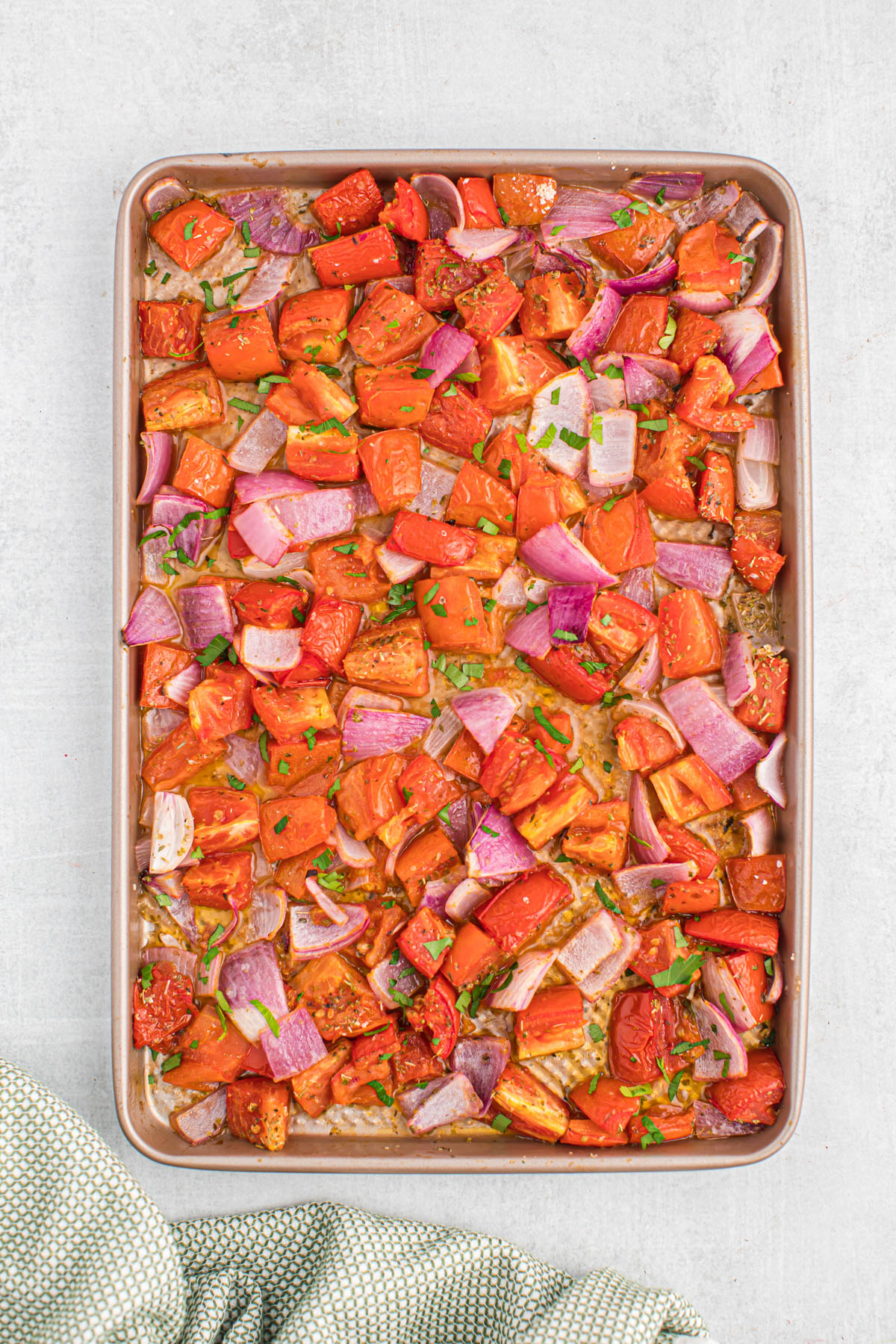 Easy to make Sheet Pan Roasted Tomatoes! Made with few simple ingredients, these tomatoes roast up in just 15 minutes! So tender and so flavorful! overhead view of roasted tomatoes on sheet pan