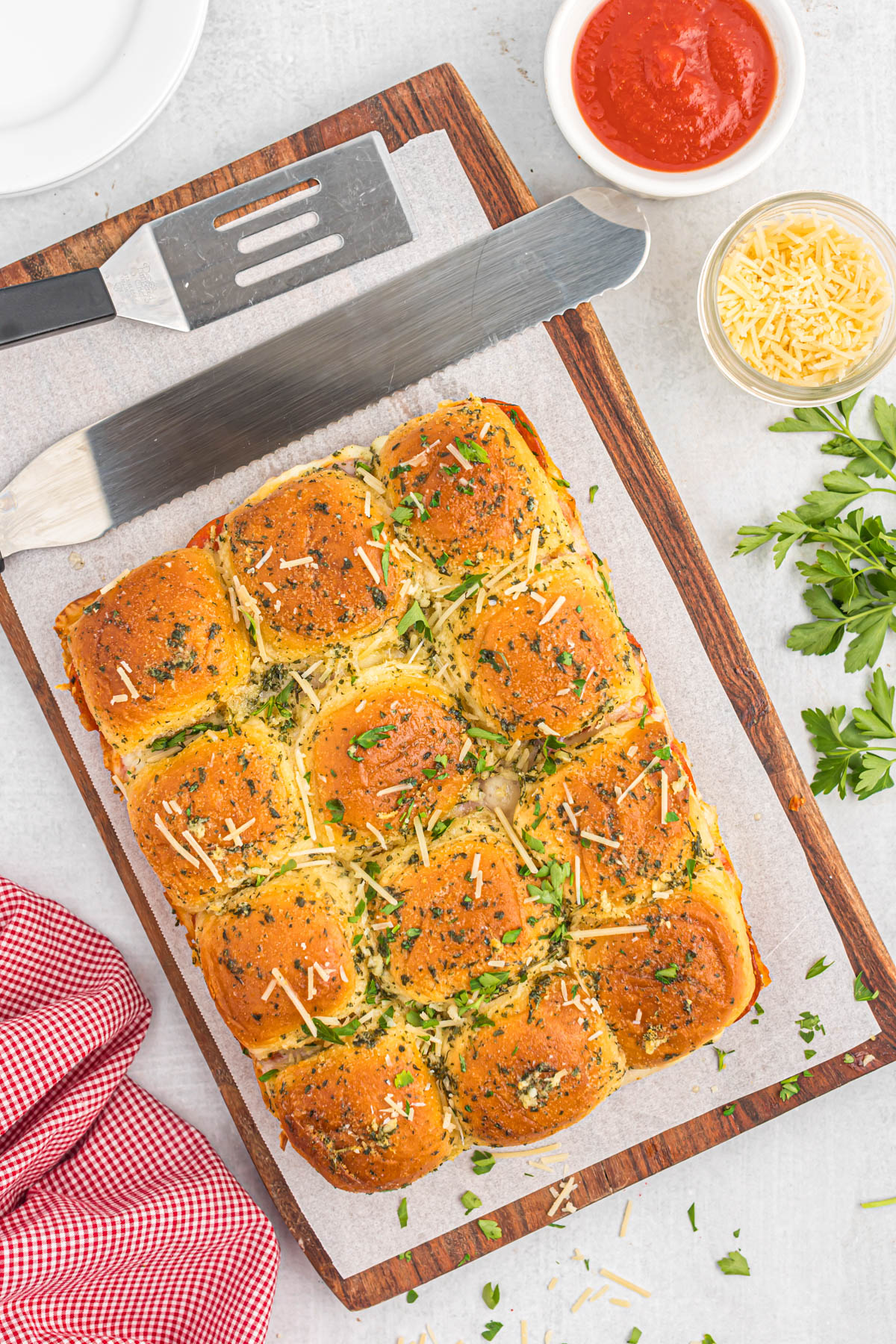 Craving pizza without the mess? Bite-sized pepperoni pizza sliders are the answer! Fluffy slider rolls meet melty cheese, tomato sauce, and pepperoni for an irresistible finger food. Perfect for game days, parties, or a quick and easy weeknight meal. pepperoni pizza sliders on wooden cutting board