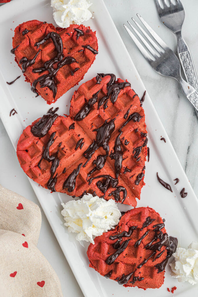 heart shaped red velvet cake mix waffles on plate