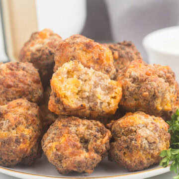 Air fryer sausage balls on plate with bite taken.