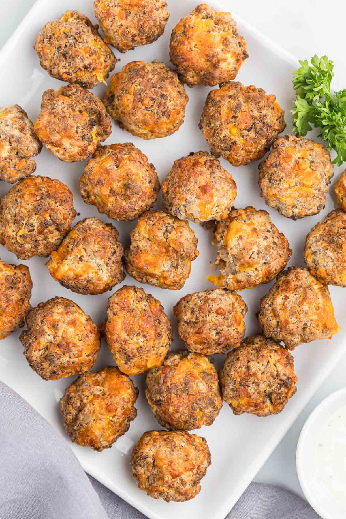 Overhead view of Air fryer sausage balls on white plate.