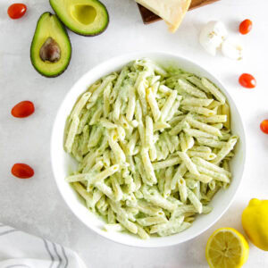 creamy avocado pasta in white bowl.
