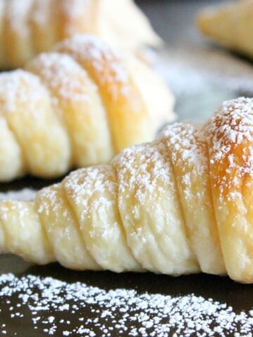 cream horn on sheet pan topped with powdered sugar.
