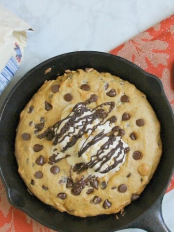 Chocolate Chip Pumpkin Skillet Cookie in skillet on orange napkin