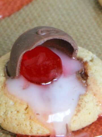 Chocolate Covered Cherry Thumbprint Cookies on brown background