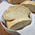 Homemade Italian Bread in gray bowl on brown cutting board