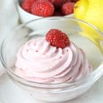 Lemon Raspberry Whipped Cream in glass bowl topped with fresh raspberry
