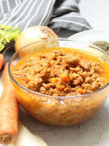 Instant Pot Turkey Ragu in glass bowl with ingredients in background