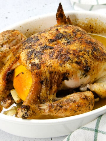 Oven Baked Whole Chicken in white baking dish