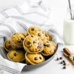 Muffins in bowl with glass of milk.