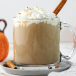 latte in glass cup topped with cream.