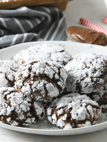 Chocolate Hazelnut Crinkle Cookies stacked on plate.