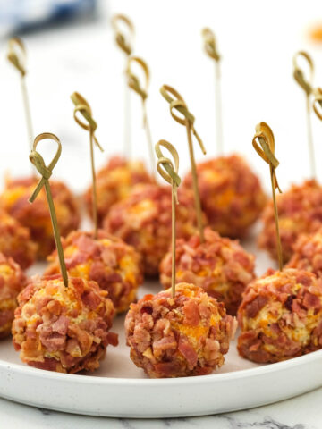 Mini Bacon Ranch Cheeseballs on white plate with toothpick.