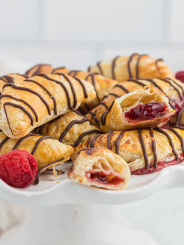 raspberry hand pies stacked on platter.