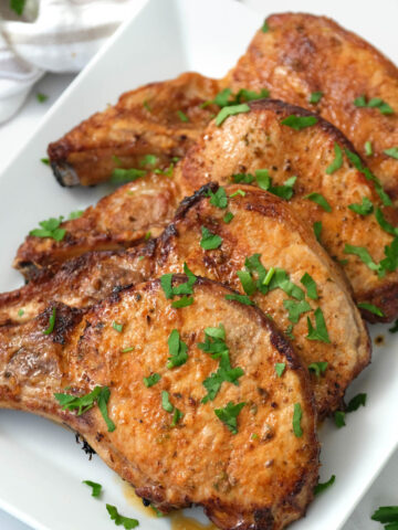 pork chops covered with fresh parsley.