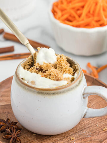 carrot cake mug cake with spoon in white mug